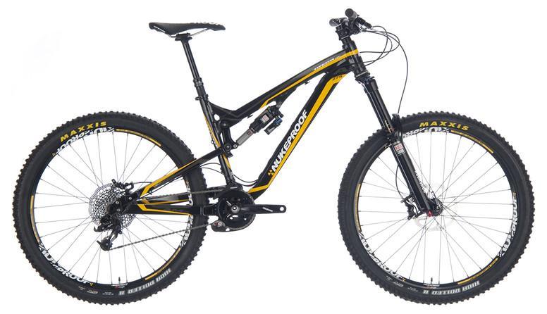 Nukeproof Mega AM 275 Pro: A black and yellow mountain bike with a sturdy frame, featuring large, knobby tires designed for off-road terrain, a front suspension system, and a single front chainring. The bike is angled to show its design and components.