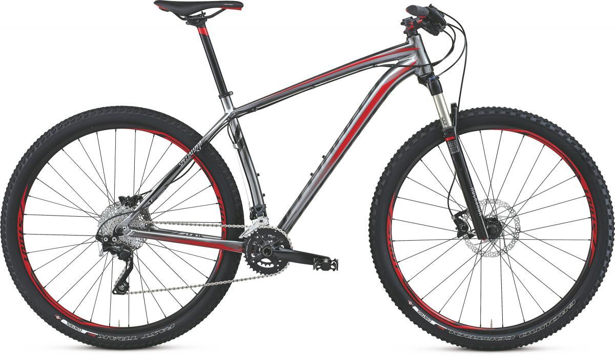 Specialized Crave Expert 29: A modern mountain bike with a sleek silver and red design, featuring wide tires, a lightweight frame, and front suspension, positioned on a white background.