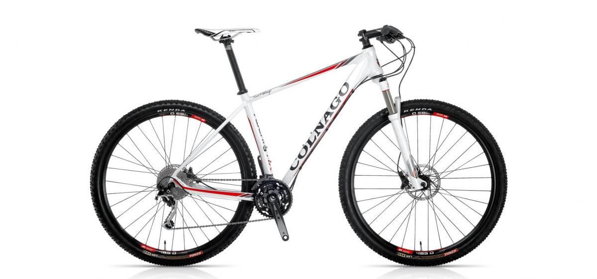 Colnago Twenty IX: A white mountain bike with red and black accents, featuring wide tires, disc brakes, and a lightweight frame. The bike is shown from the side, highlighting its sleek design and gear setup.