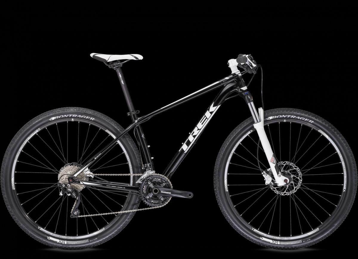 Trek Superfly 5: An image of a black and white mountain bike featuring a lightweight frame, front suspension, and disc brakes. The bike has Bontrager tires and Shimano components, showcasing its sporty design and suitability for off-road cycling. The background is black, highlighting the bike's features.