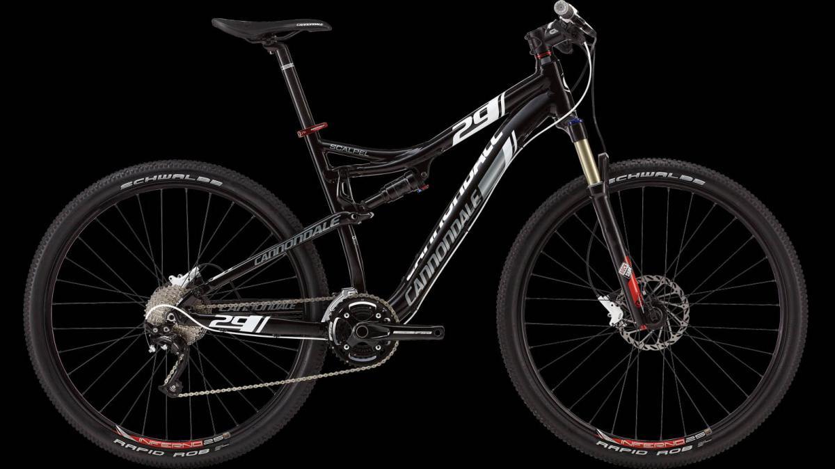 A Cannondale Scalpel 29 mountain bike featuring a sleek black and white design. The bike has 29-inch wheels, prominent suspension forks, and is equipped with Schwalbe tires, showcasing its performance capability for off-road trails. The bicycle is positioned against a black background, highlighting its distinct features and modern design.