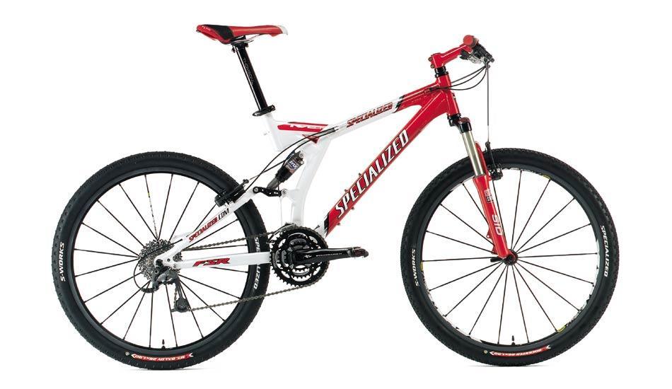 Specialized S-Works: Alt text: A red and white mountain bike with a sturdy frame, front suspension, and knobby tires, positioned against a plain background. The bike features a specialized design, showcasing the brand name prominently on the frame.