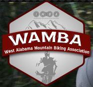 Logo of the West Alabama Mountain Biking Association (WAMBA), featuring a hexagonal design with mountainous graphics and a silhouette of a mountain biker.
