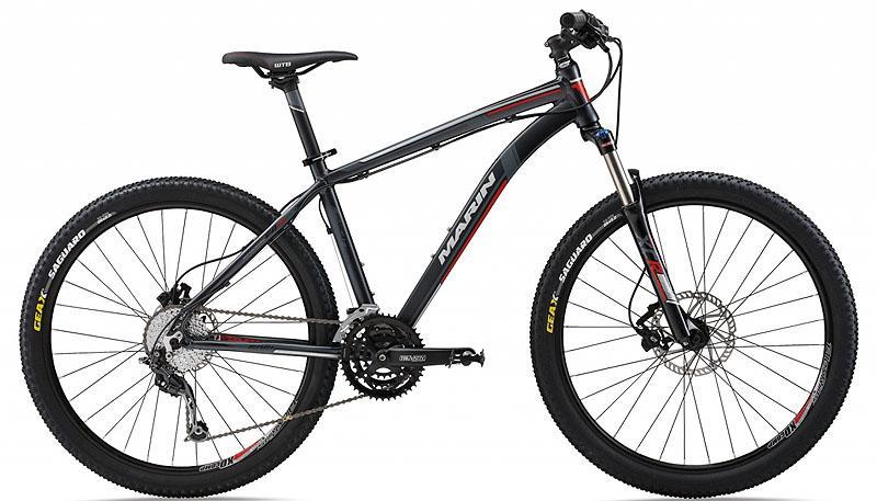 Marin Bobcat Trail: Mountain bike featuring a sleek black and gray frame, front suspension, and knobby tires, designed for off-road cycling. The bike is equipped with disc brakes and a gear system, showcasing a modern and sporty design suitable for trails and rugged terrain.
