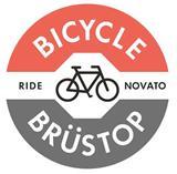 Circular logo featuring the text "Bicycle Brüstop" and "Ride Novato," with an illustration of a bicycle in the center. The logo has red, white, and gray sections, conveying a vibrant and active theme related to cycling.