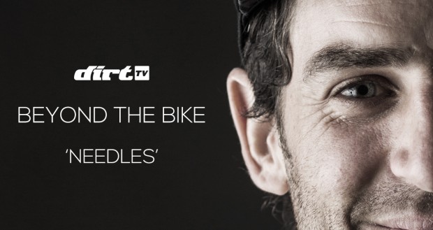 Close-up of a man’s face with a focused expression, accompanied by the text "dirtTV" in the top left corner and the words "BEYOND THE BIKE 'NEEDLES'" prominently displayed. The background is dark, emphasizing the subject's features.