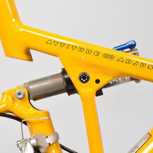 Cannondale Jekyll: Close-up of a bright yellow bicycle frame featuring the text "ATTITUDE ADJUST" near the top tube, with visible suspension components and a travel adjuster.