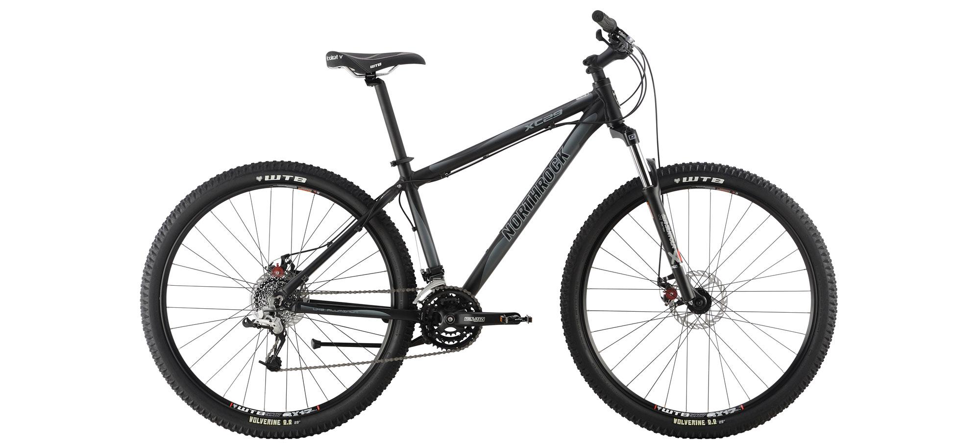 Northrock XC29: Mountain bike with a black frame, front suspension, and knobby tires, showcasing the drivetrain and braking system. The bike is positioned on a plain background.