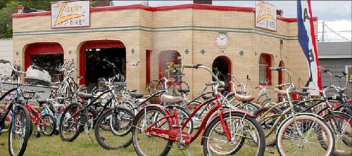 Alt text: A vintage bicycle shop with a brick exterior, featuring a sign that reads "Zee