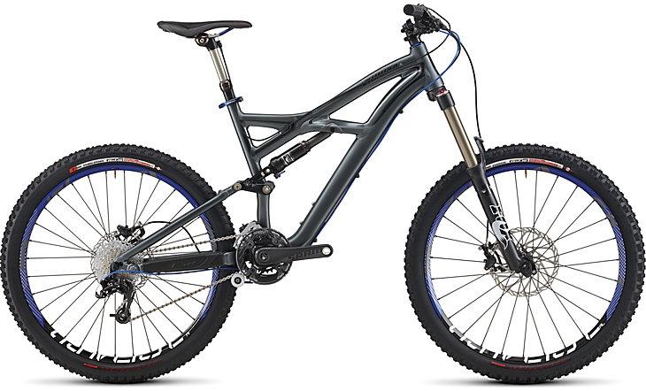 Specialized Enduro SL Pro: A modern mountain bike with a sleek gray frame, featuring front suspension and wide tires designed for off-road trails. The bike includes gears and disc brakes, showcasing its sturdy construction and ability to handle rugged terrain.