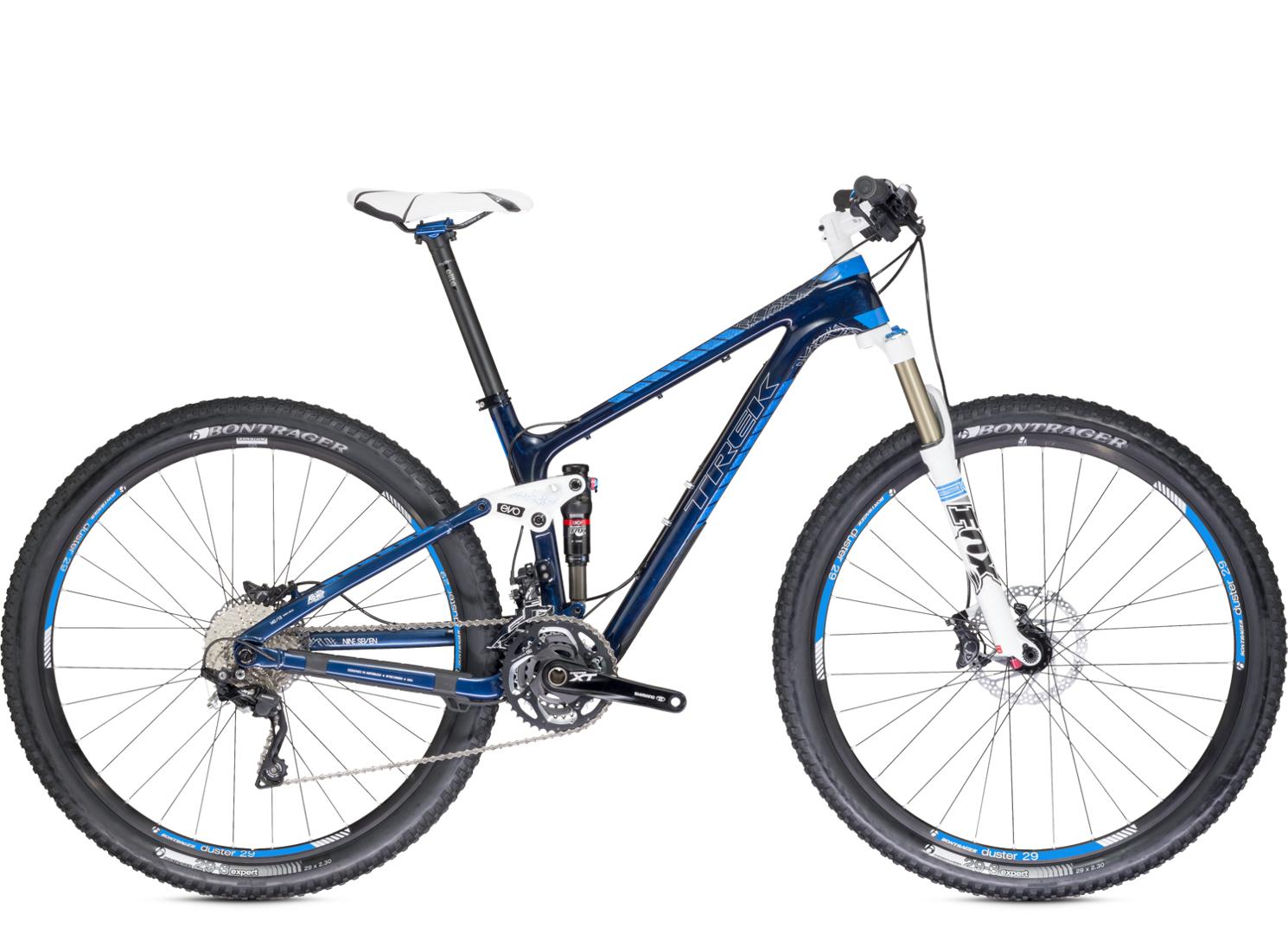 Trek Fuel EX 9.7 29: A sleek blue mountain bike with a white saddle, featuring front suspension and wide black tires. The bike showcases a modern design with a lightweight frame, and is equipped with Shimano XT components for smooth gear shifts. The wheels are labeled "Bontrager," emphasizing performance and durability.