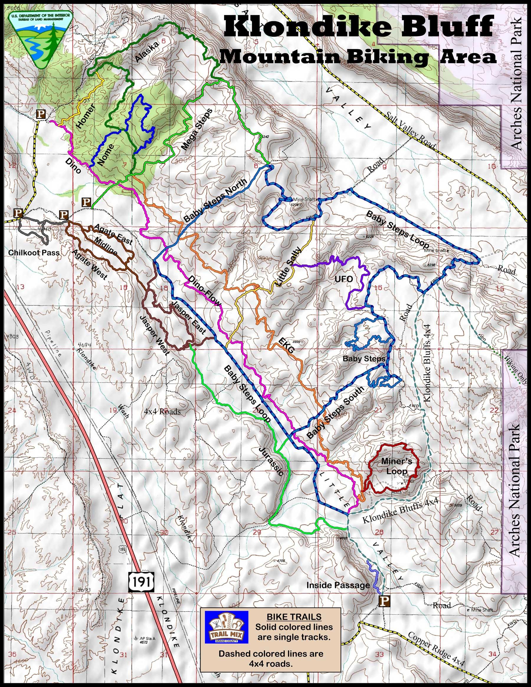 Map of the Klondike Bluff Mountain Biking Area, featuring various bike trails highlighted in solid colors for single tracks and dashed lines for 4x4 roads. Key trails include Baby Steps, Miner’s Loop, and more, alongside geographical features and parking areas marked. Klondike Bluffs mountain bike trail.