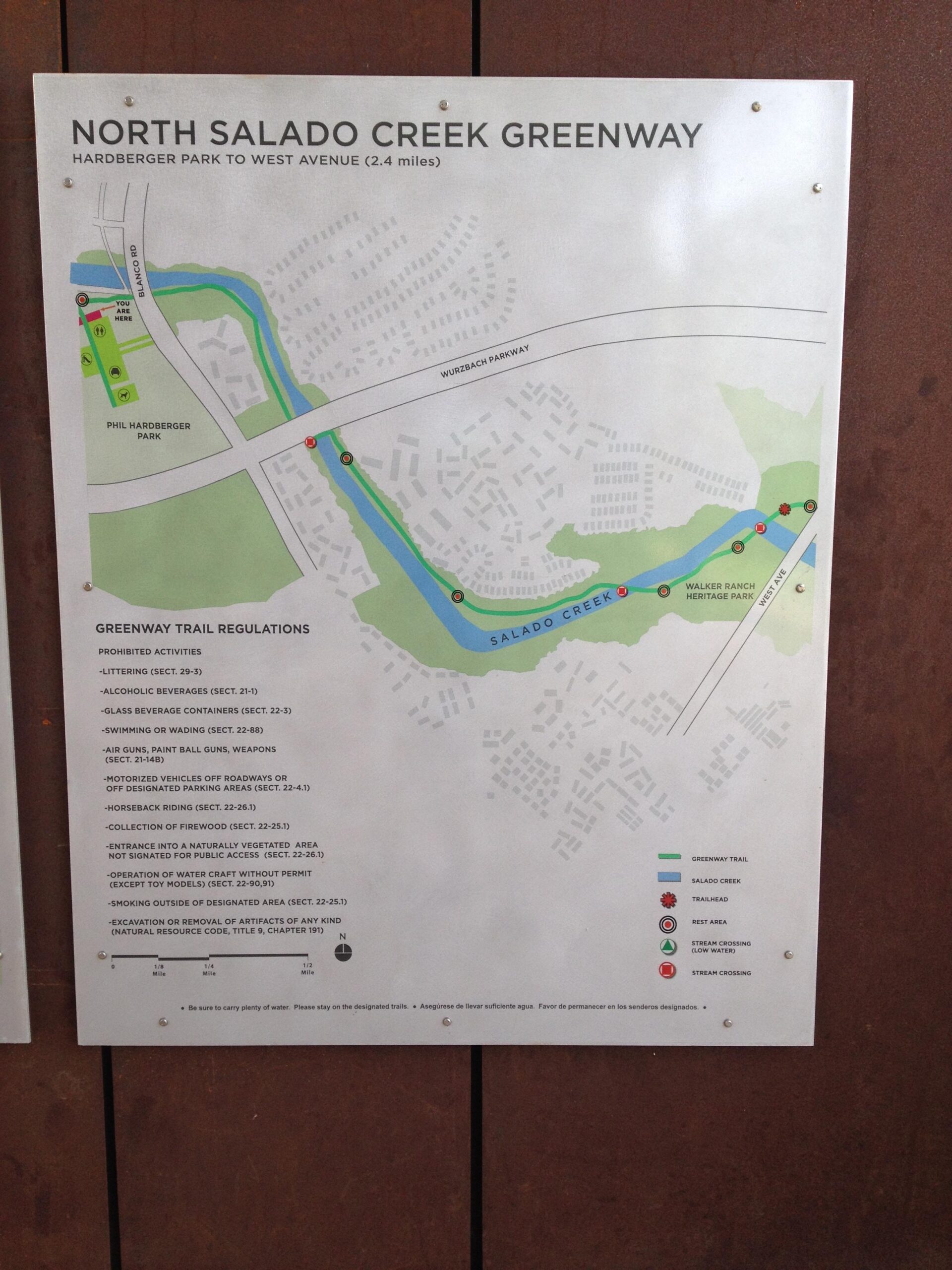 Map of the North Salado Creek Greenway, highlighting a 2.4-mile trail from Hardberger Park to West Avenue. The map includes trail regulations, prohibited activities, and various landmarks such as parks and rest areas along the greenway. Salado Creek mountain bike trail.