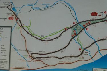 Map of the Rock Ovens Trail and surrounding area, featuring various trails, lakes, and points of interest. Key elements include Chute Lake Lodge, Robinson Creek, and connections to nearby roads and parks, along with distance markers for different segments of the trails. A legend outlines symbols for trails, roads, and facilities. Kettle Valley Railway Trail (KVR) Myra Canyon to Penticton return mountain bike trail.