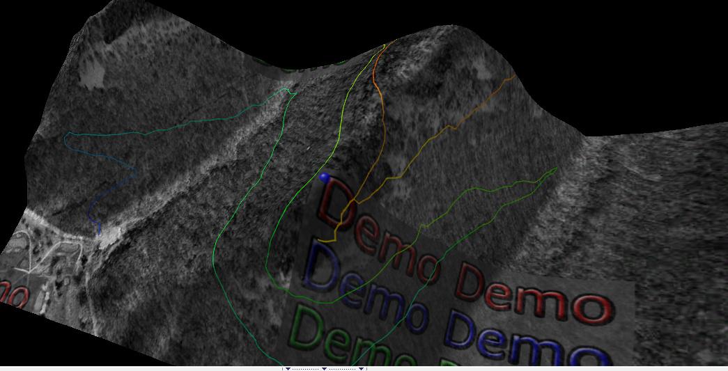 3D visualization of a topographic landscape featuring multiple colored lines representing trails or paths. The image includes overlaid text that reads "Demo Demo" in various colors and sizes, set against a dark background. Rotary Vista mountain bike trail.