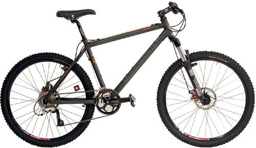 Motobecane Fantom Comp: A black and gray mountain bike with thick tires, a lightweight frame, and front suspension, positioned against a white background.
