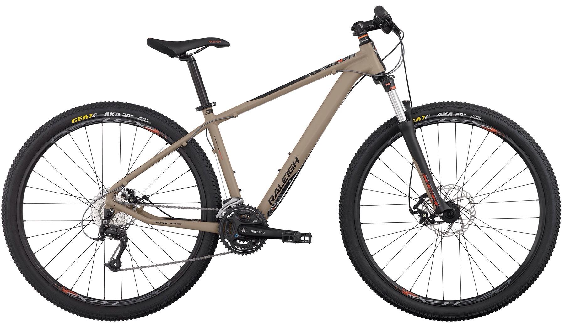 Raleigh Talus 29er: A mountain bike with a sleek, modern design featuring a tan frame, black handlebars, and 29-inch wheels. The bike is equipped with a front suspension fork and disc brakes, showcasing durable tires designed for off-road terrain.
