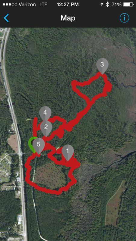 Map displaying a hiking trail outlined in red on a satellite view of a forested area, with numbered markers indicating points of interest. A green marker highlights the starting or current location. Henderson Pond / Camp Lejeune mountain bike trail.