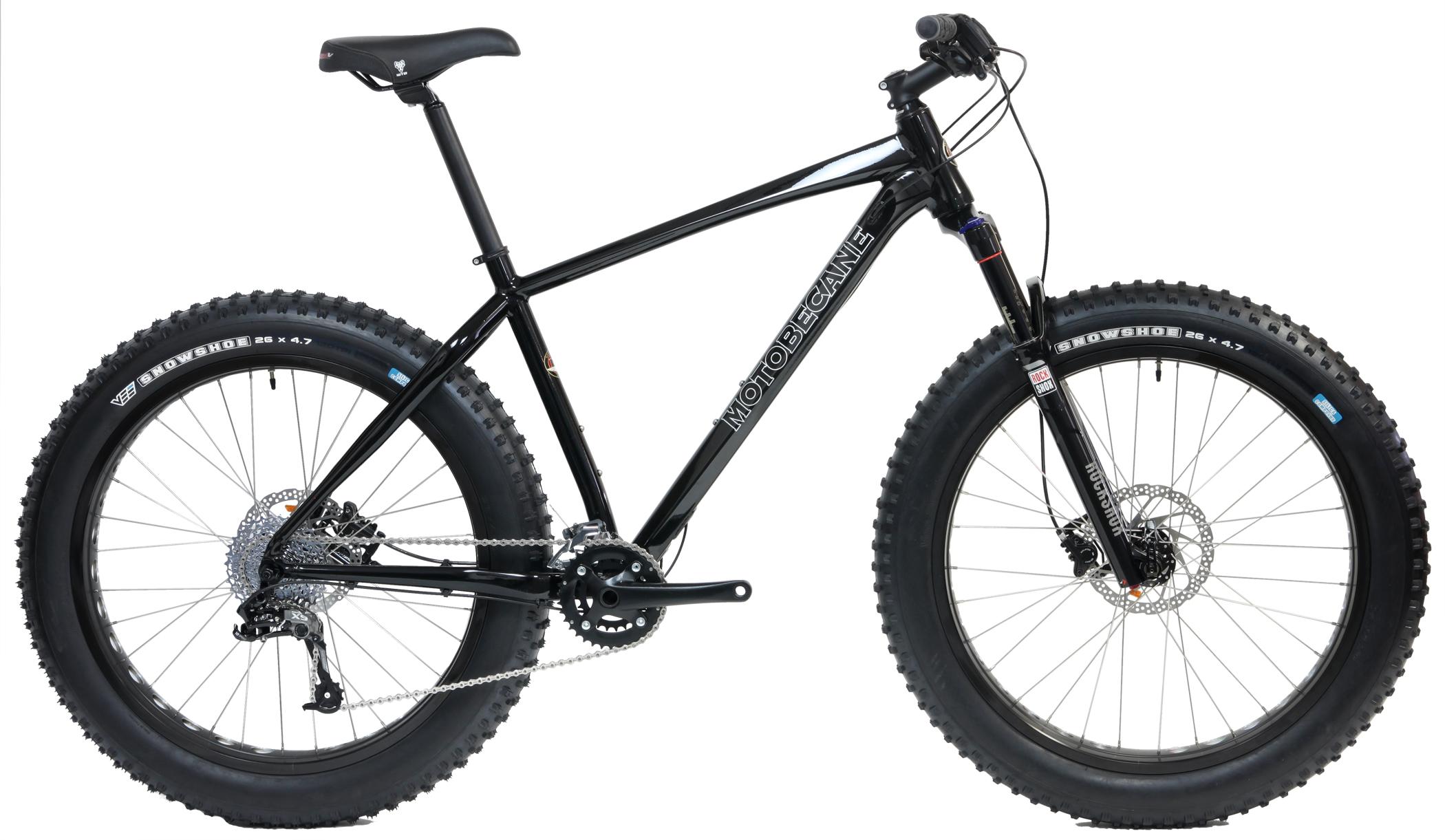 Motobecane NightTrain Bullet: A black fat tire mountain bike with a sturdy frame, wide tires, and a gear system, shown against a plain white background.