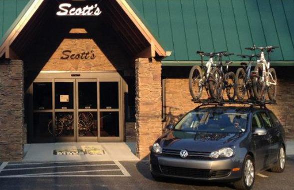 A Volkswagen car parked in front of a store named "Scott