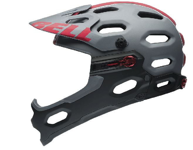 A modern mountain bike helmet in gray with red accents, featuring ventilation holes and a sturdy chin guard for enhanced protection. The brand name "Bell" is prominently displayed on the front.