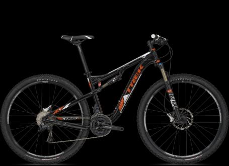 A black and orange mountain bike from the brand Trek, featuring a sleek frame, front suspension, and knobby tires designed for off-road terrain. The bike is positioned against a black background, highlighting its features.