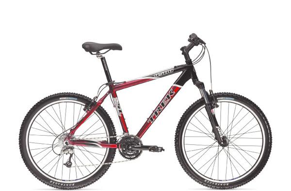Trek 4500: Alt text: A black and red Trek mountain bike is displayed on a white background. The bike features thick tires, a front suspension fork, and a multi-gear system.