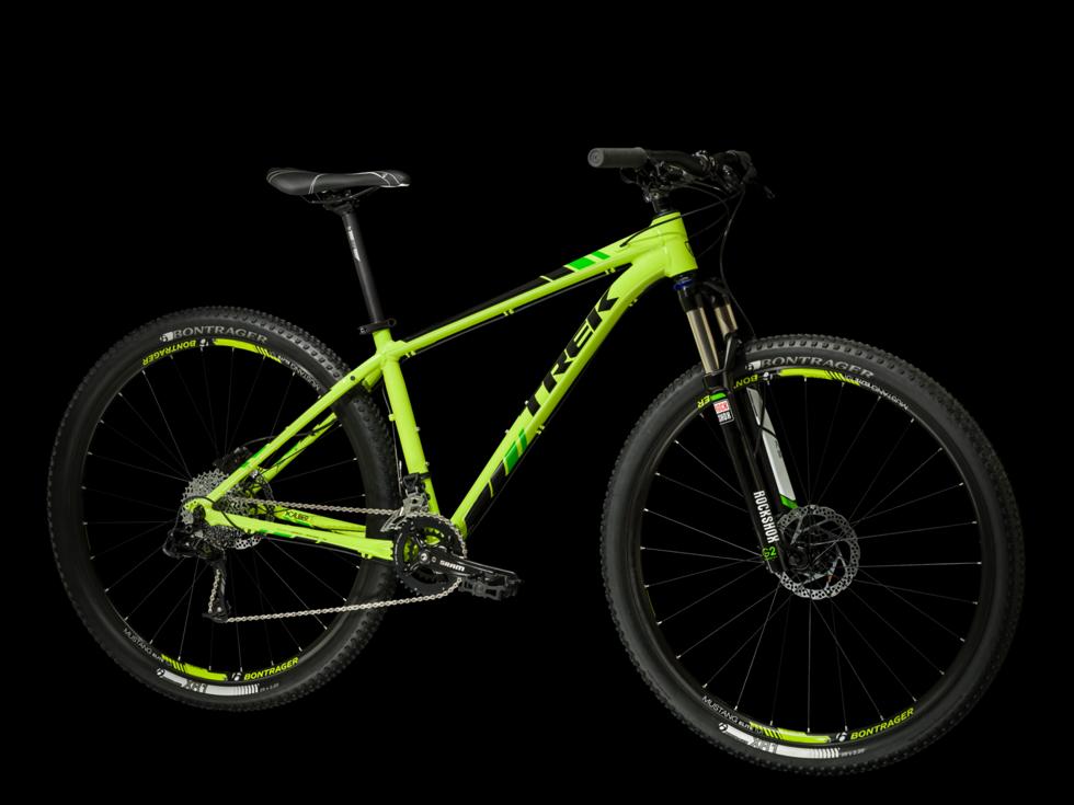 Trek X-Caliber 8: A bright green mountain bike with black accents, featuring a lightweight frame, front suspension, and thick tires suitable for off-road riding, displayed against a black background.