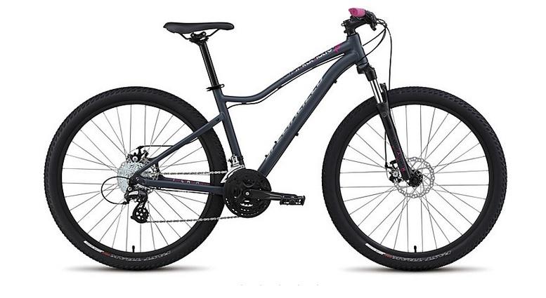 Specialized Jynx 650B: A gray women's mountain bike with pink accents, featuring wide tires, disc brakes, and a sturdy frame designed for off-road terrain. The bike is positioned on a white background.