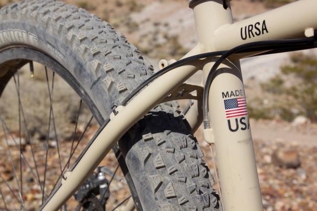 Chumba Ursa: Close-up of a beige mountain bike frame featuring the name "URSA" and a sticker indicating it is "Made in USA" with the American flag. The bike