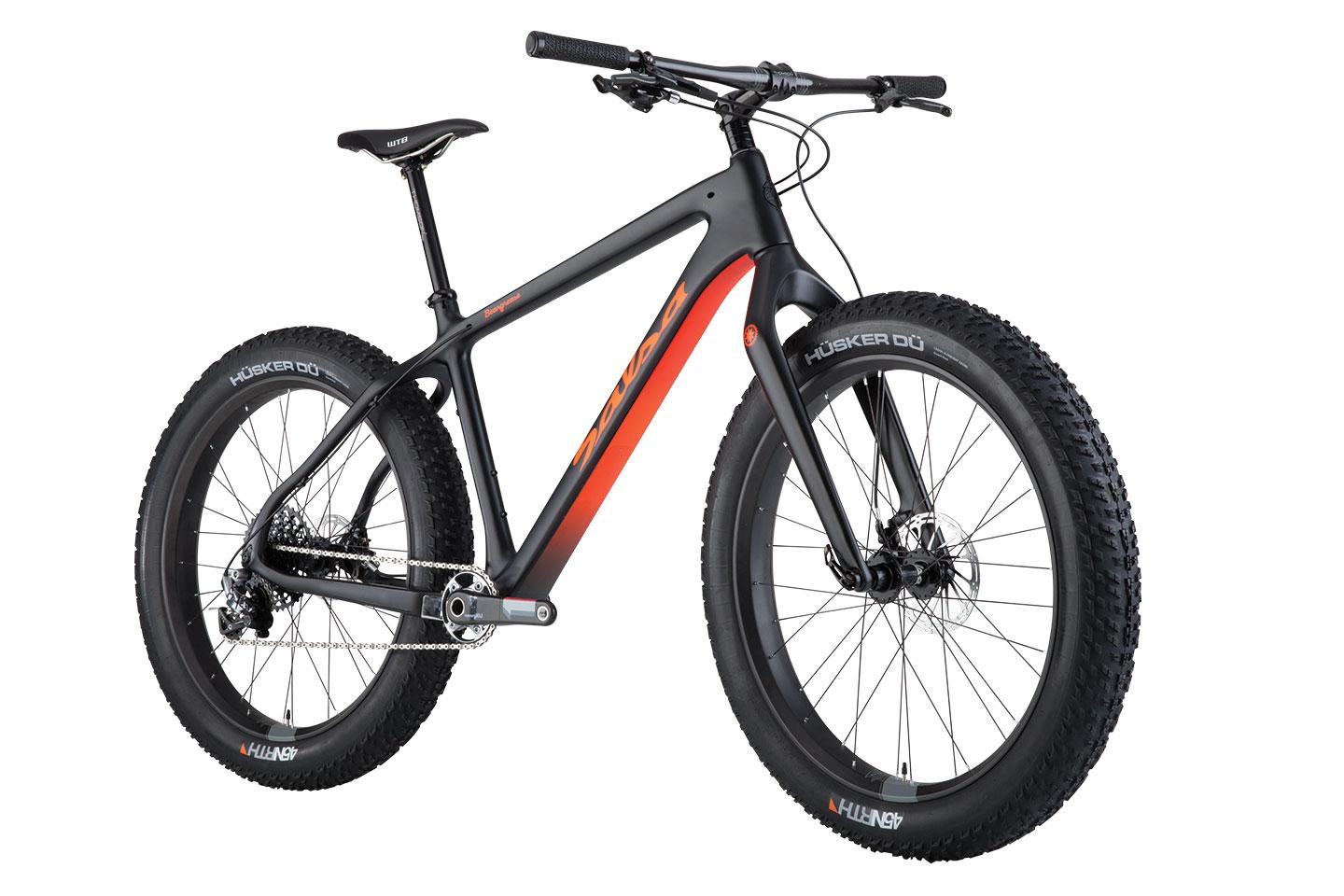 Salsa Beargrease Carbon XX1: Alt text: A black and orange fat bike with wide tires, featuring a sleek frame, prominent handlebars, and a comfortable seat, positioned at an angle to showcase its design and components.