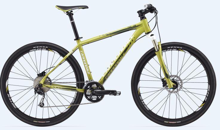 Cannondale Trail SL 29 3: A green mountain bike with a lightweight frame, front suspension, and disc brakes, featuring black tires and a gear system. The bike is positioned against a light blue background.