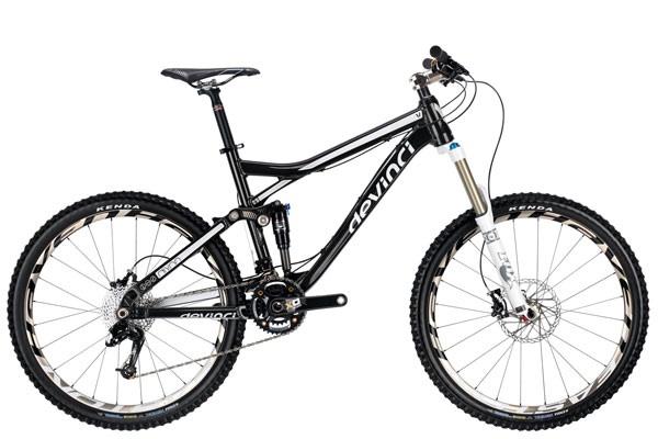 Devinci Dixon RS: A black mountain bike with a full suspension design, featuring large wheels and a front fork for shock absorption. The bike has a sleek frame with prominent branding and is equipped with disc brakes and knobby tires, suitable for off-road terrain.
