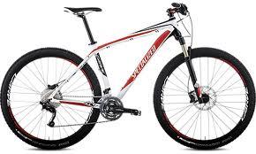 Specialized Carve Pro: Mountain bike with a white and red frame, featuring thick tires and front suspension, designed for off-road cycling.