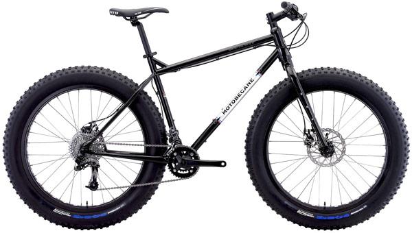 Motobecane Lurch: A black fat bike with wide tires, featuring a simple frame design, disc brakes, and a gear shift mechanism, is shown against a white background. The bike is designed for off-road riding.