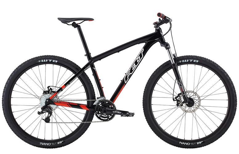 Felt Nine 80: A black and red mountain bike with a lightweight frame, featuring wide tires and disc brakes. The bike is positioned at a slight angle, showcasing its sturdy construction and gear system.