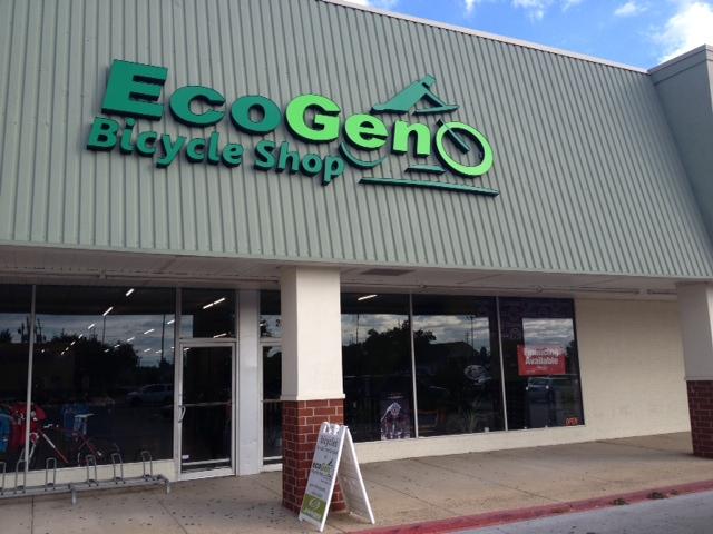 Front view of EcoGeno Bicycle Shop, featuring a green and blue sign with the shop