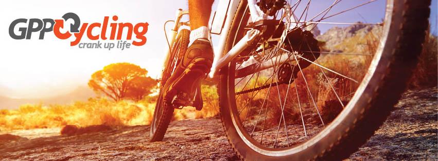 A close-up of a cyclist's feet and bicycle on a rocky trail, with a sunset or sunrise in the background. The image features the text "GPP Cycling" and the tagline "crank up life" prominently displayed.