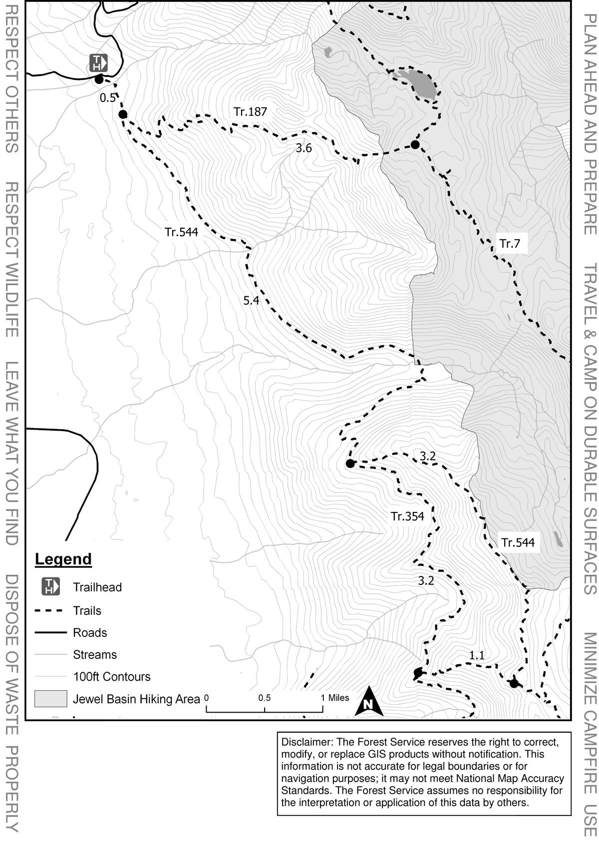 Map of the Jewel Basin Hiking Area, featuring trails, roadways, and elevation contours. Key locations, including trailheads and mileage markers, are indicated. The map includes a legend for understanding symbols and a disclaimer regarding the accuracy of the information provided. Broken Leg Divide Trail #353 mountain bike trail.