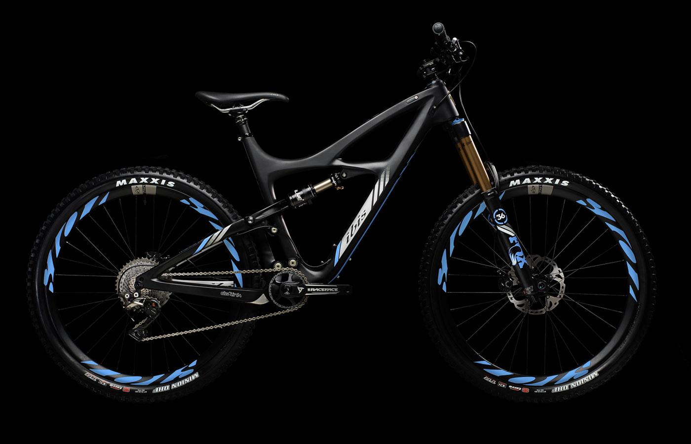 Ibis Mojo HD3: A sleek, modern mountain bike featuring a black frame with blue accents. The bike has a suspension fork, wide tires with "Maxxis" branding, and a complex gearing system. The background is solid black, highlighting the bike's design and components.