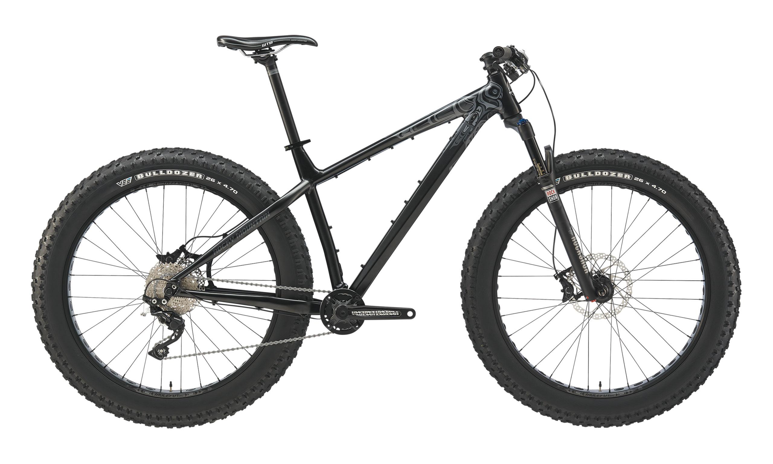 Rocky Mountain Blizzard: A black fat tire mountain bike with a sturdy frame, wide tires labeled "Bulldozer," and front suspension. The bike is shown from a side view, highlighting its design and features, including the disc brakes and gear system.