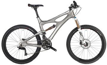 A silver mountain bike with a sleek design featuring front suspension and wide tires, positioned on a white background. The bike is equipped with disc brakes and has a modern, lightweight frame suitable for off-road riding.