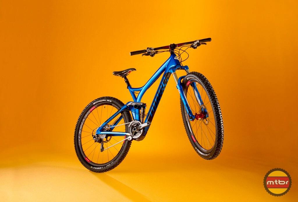 Niner R.I.P. 9 RDO: A blue mountain bike is displayed against a vibrant yellow background, featuring sturdy tires, a lightweight frame, and detailed components, highlighting its suitability for off-road cycling.
