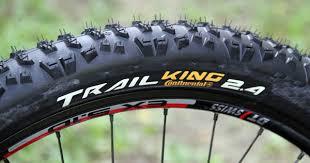 Continental Trail King: Close-up image of a mountain bike tire labeled "Trail King 2.4" from Continental, featuring a rugged tread pattern designed for off-road terrains.