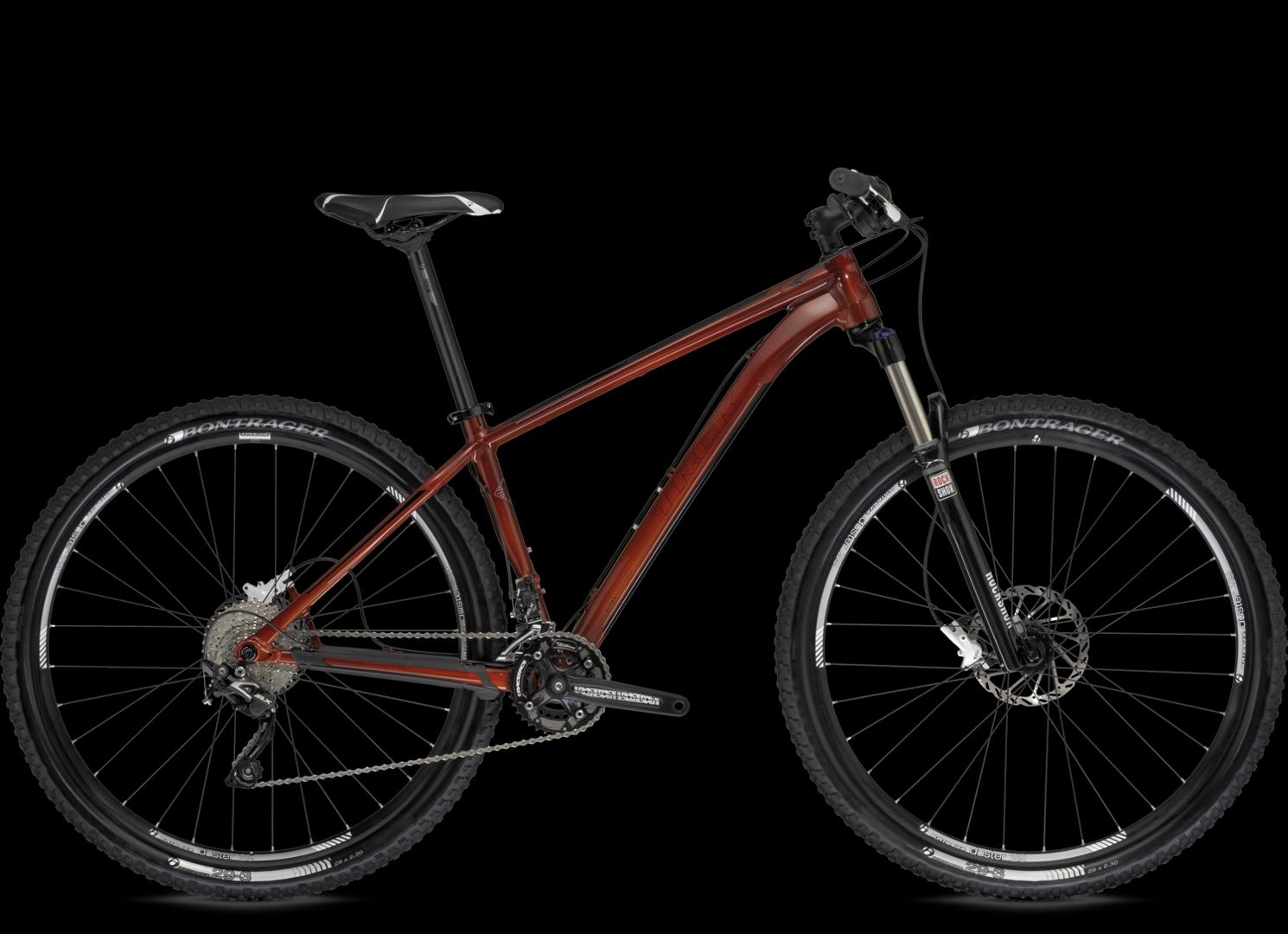 Trek Stache: A mountain bike with a sleek, dark amber frame, featuring front suspension, wide tires, and a modern design, displayed against a black background.