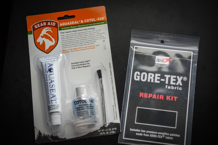 Image showing a Gear Aid Aquaseal and Cotol-240 urethane repair kit alongside a Gore-Tex repair kit. The Aquaseal package includes instructions for various fabric repairs, highlighting its use for waders and other outdoor gear. The Gore-Tex kit is designed for patching and repairing Gore-Tex fabrics. Both kits are displayed on a dark background.