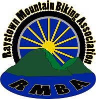 Logo of the Raystown Mountain Biking Association (RMBA), featuring a stylized design with mountains, a sunburst in the background, and the acronym "RMBA" at the bottom. The color scheme includes blue, yellow, and green.