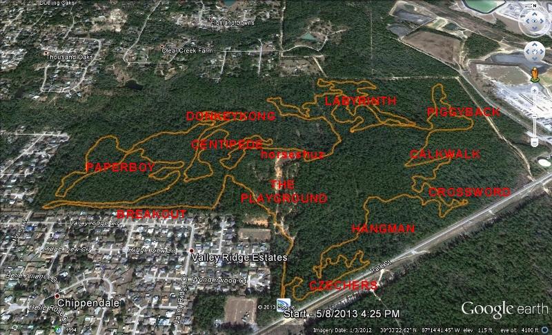 Satellite image of a wooded area with trails and points of interest labeled, including "Dorksled", "Paperboy", "The Playground", and "Labyrinth". The map shows the surrounding residential neighborhood of Valley Ridge Estates and various paths and landmarks within the forested region, outlined in orange and marked in red text. Games Loop mountain bike trail.