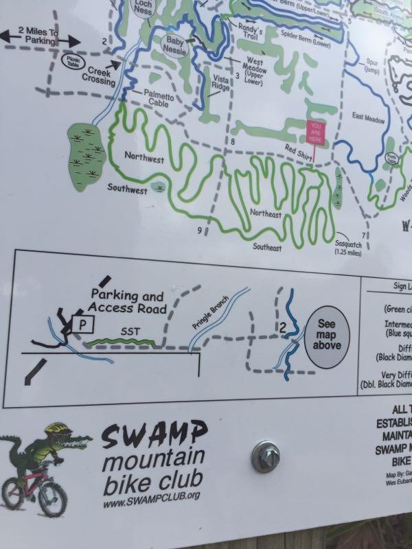 Map showing bike trails and parking area for Swamp Mountain Bike Club. The map includes various trails labeled with difficulty levels and features like creek crossings, access roads, and trail names. The location marker indicates “You Are Here.” The club's logo and website are also visible at the bottom. Balm Boyette Scrub Preserve mountain bike trail.