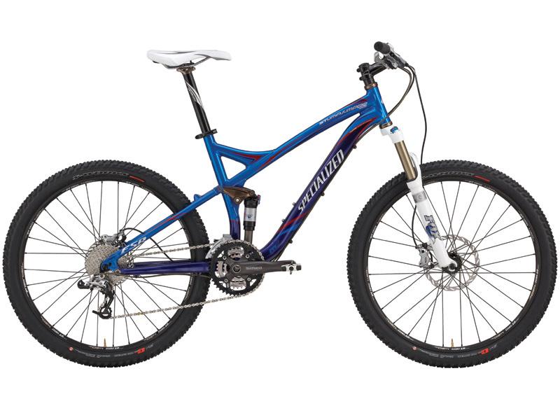 Specialized Stumpjumper FSR: A blue and silver mountain bike featuring a lightweight frame, front suspension, and disc brakes. The bike has wide tires suitable for off-road terrain and is equipped with a gear system for varied terrain performance.